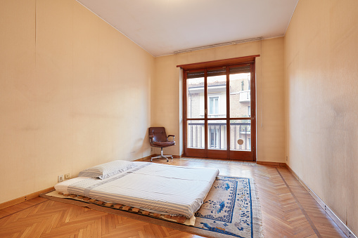 Bedroom with tatami bed and armchair in old apartment