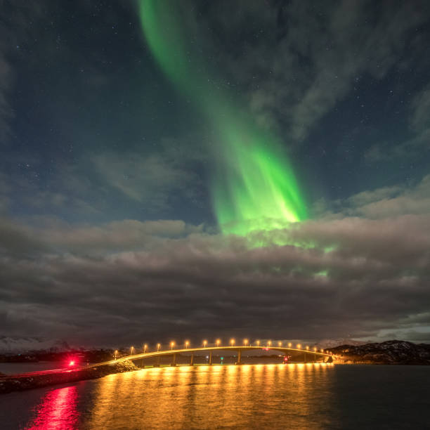 istock Northern lights aurora borealis between clouds in Sommaroy, Tromso, Norway 1206192816