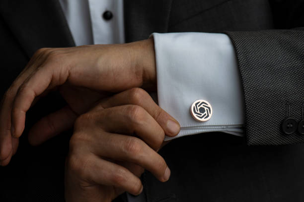 Close-Up Of Man Hand Adjusting Cuff Link Man in white shirt wearing cufflinks. cufflink stock pictures, royalty-free photos & images