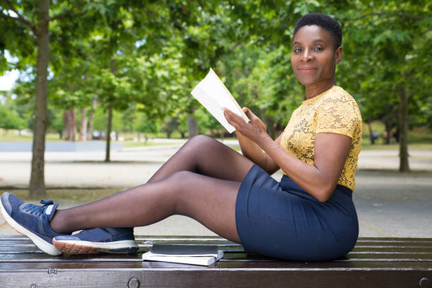 istock Beautiful smiling woman holding book and looking at camera 1206193072