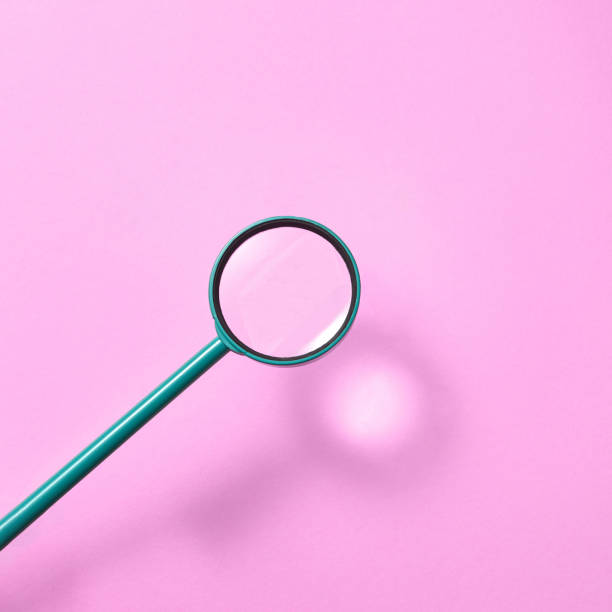 istock Magnifying glass above pink background with shadows. 1206195446