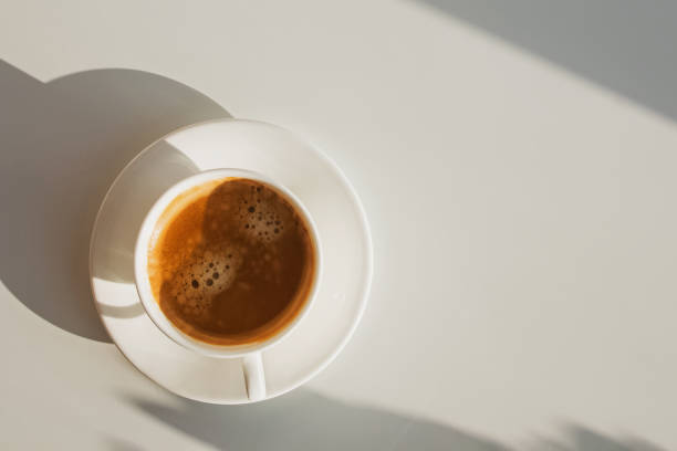 istock Cup of coffee atanding on the white table in sunlight 1206197068