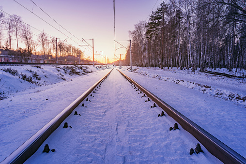 Highspeed train moves fast through the station at winter sunset.
