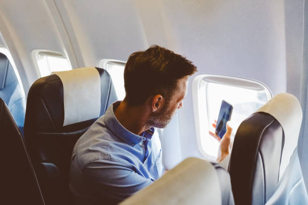 istock Man using smart phone in the airplane 1206203118