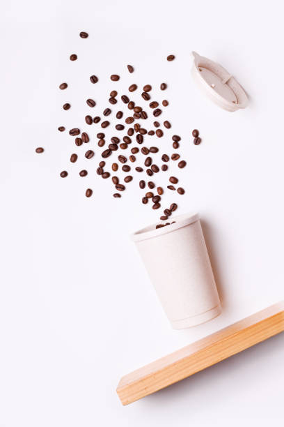 istock reusable coffee cup in flight with coffee beans on a white background. 1206203405