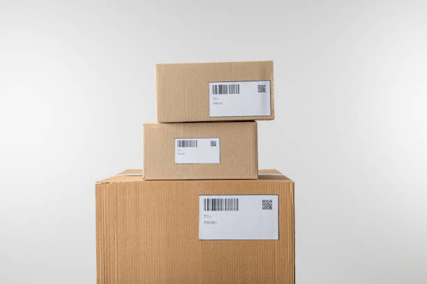 istock Stacked cardboard boxes with barcodes and qr codes on cards isolated on grey 1206203809