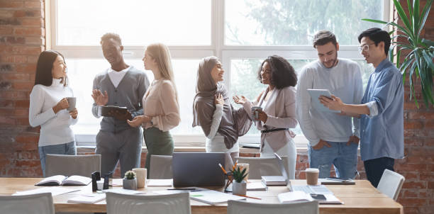 multiracial young happy people sharing ideas while coffe break - office fun group of people white collar worker imagens e fotografias de stock