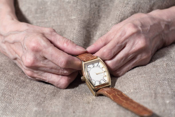 istock Old woman's hands hold a wristwatch close-up 1206208097