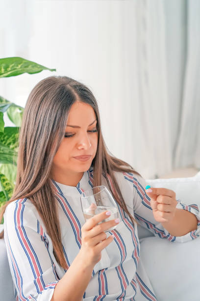 istock A young girl drinks a pill from pain 1206210297