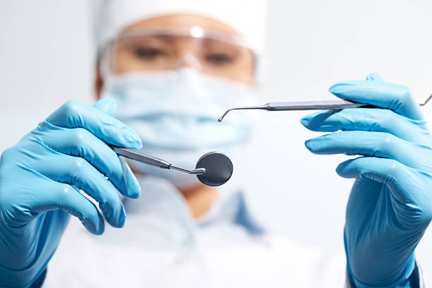 Instruments Image of assistant in medical uniform holding dentistry tools in hands dental equipment hand stock pictures, royalty-free photos & images