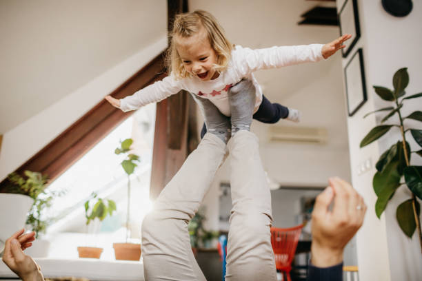 istock Daughter flying on fathers legs 1206215083