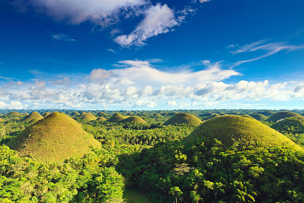 chocolate hills unter blauem himmel in den philippinen. - bohol stock-fotos und bilder