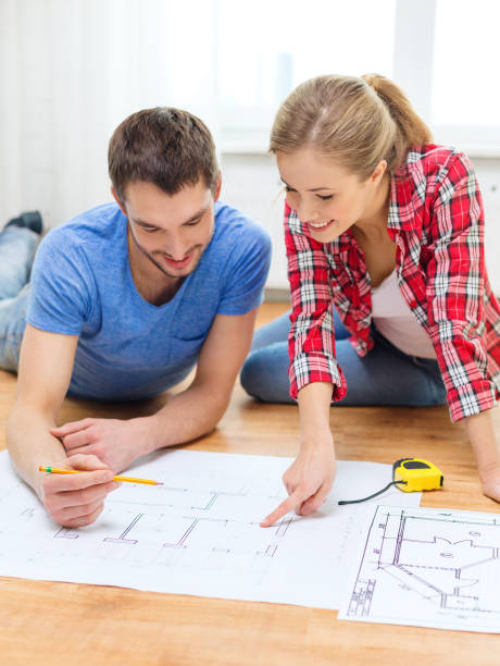 istock smiling couple looking at blueprint at home 1206217047