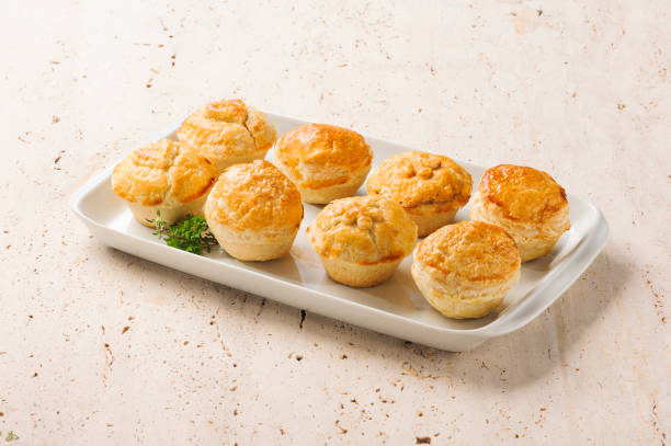 Tradicional brazilian and portuguese mini pie or empada Eight tradicional brazilian and portuguese mini pie or empada, with a crispy golden-brown crust, ready to eat, on a ceramic plate. savory stock pictures, royalty-free photos & images