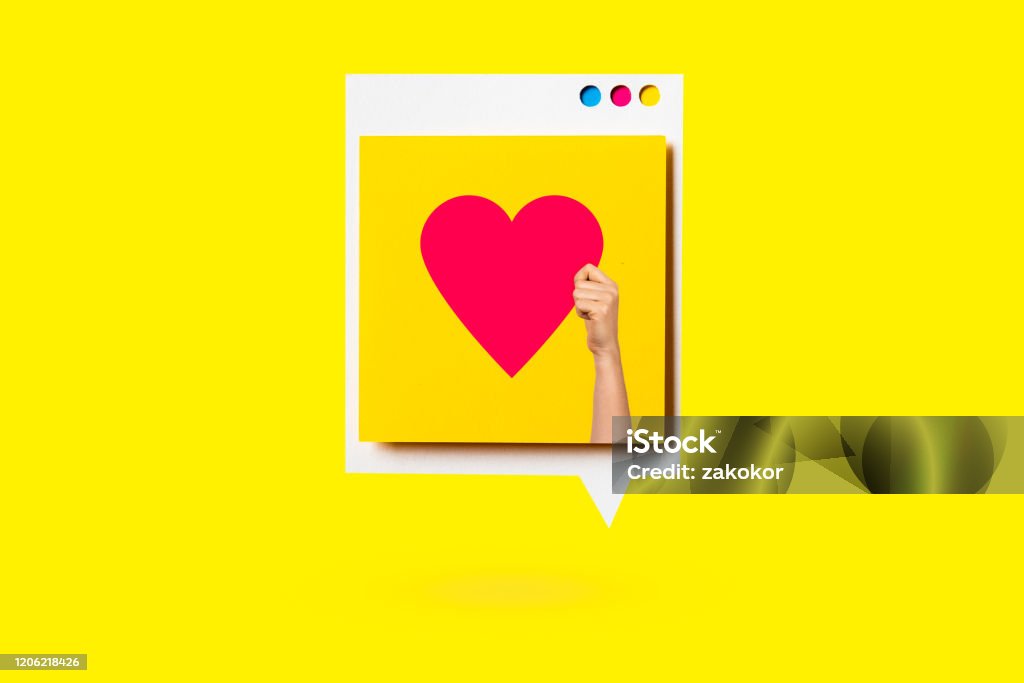 Paper cutout of red heart symbol on a white speech bubble on yellow background. Concept of social media and digital marketing. Auto Post Production Filter Stock Photo
