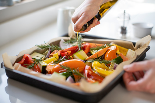 Primer plano de la bandeja de condimento de verduras para asar con aceite de oliva listo para comida vegana photo