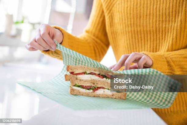 Close Up Of Woman Wrapping Sandwich In Reusable Environmentally Friendly Beeswax Wrap Stock Photo - Download Image Now
