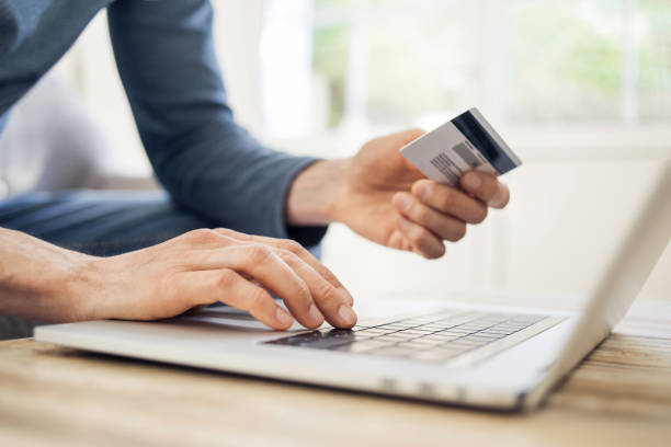 istock Man shopping online using laptop computer and credit card 1206219769
