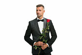 Black tie dress code for evening events. tuxedo man with rose flower. happy valentines day. special occasion. male formal style of clothing. handsome man black tux suit. sexy man on romantic date