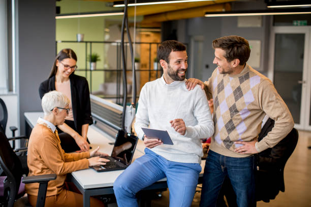 istock Business people working and communicating while standing in  the office together with colleagues sitting in the background 1206222147