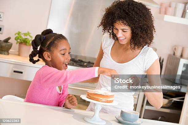 Mother And Daughter Enjoy Icing A Cake Together Stock Photo - Download Image Now - Cake, Decorating a Cake, Family