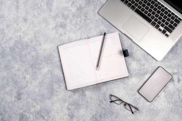 istock Flat lay office desktop work space of laptop , pen, note book and Glasses on gray background, top view with copy space 1206223012