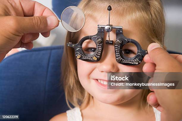 Optometrist Giving Young Girl An Eye Examination Stock Photo - Download Image Now - 40-49 Years, Adult, Care