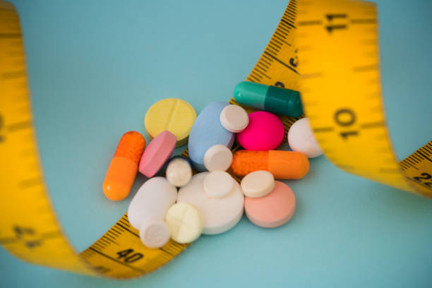istock Medicine pills or capsules and rule on blue background with copy space for text, 1206223491