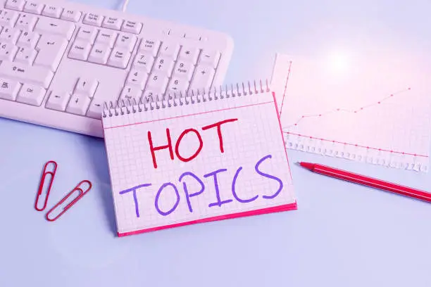 Photo of Conceptual hand writing showing Hot Topics. Business photo showcasing subject that a lot of showing are arguing and discussing Paper blue keyboard office study notebook chart numbers memo.