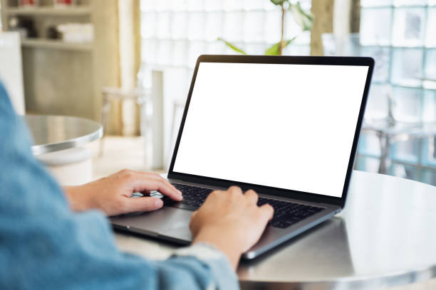 una mujer que usa y escribe en la computadora portátil con pantalla de escritorio blanca en blanco - dispositivo de pantalla fotografías e imágenes de stock