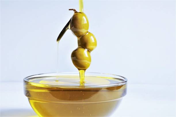 Pouring olive oil with three olive photo isolate on white stock photo