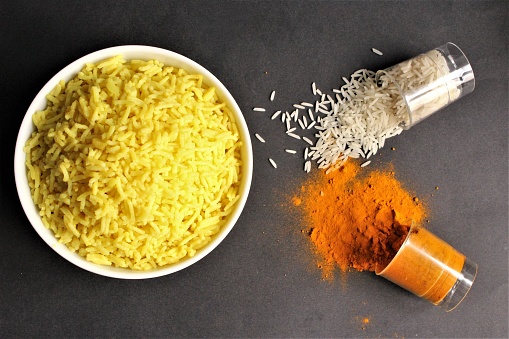Bowl of rice cooked from white rice with turmeric power Asian tradition food   photo isolate on black top view