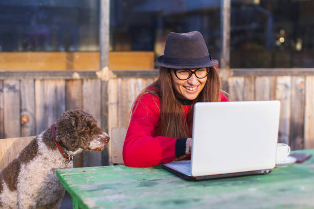 woman working with cute dog on laptop