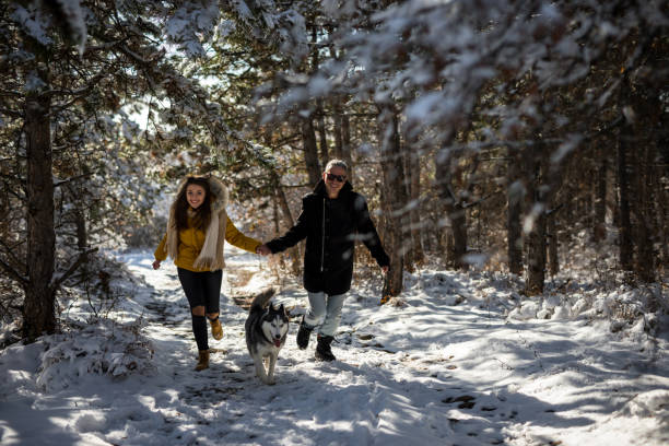 istock Couple with Husky dog running on snow 1206236025