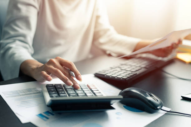 istock Woman accountant or banker use calculator and computer on table at office 1206237699