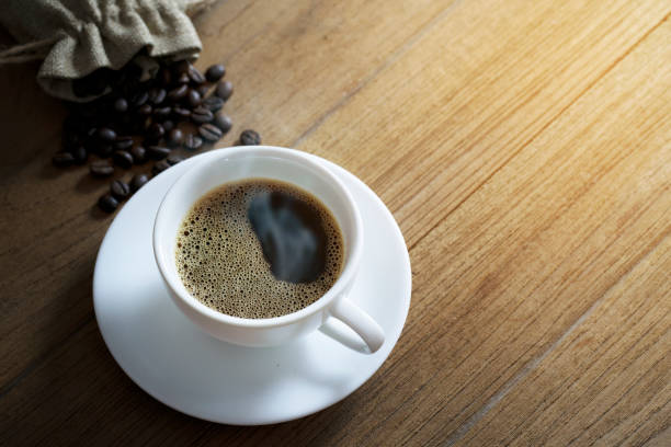istock white coffee cup and coffee beans on wooden background. Top view. 1206237950
