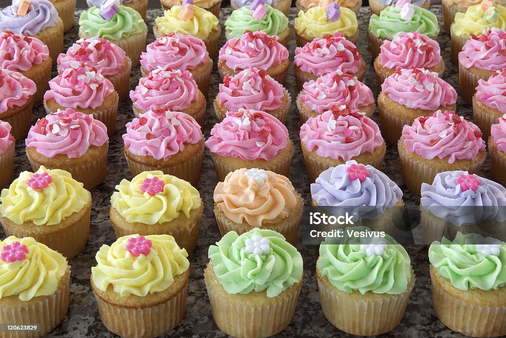 Rows of Pastel Cupcakes Rows and rows of many pastel-colored cupcakes arranged in a grid pattern. Baking Stock Photo