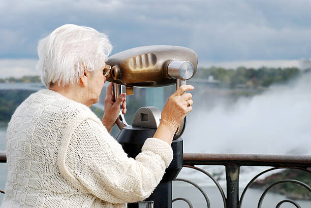 istock senior woman using binoculars at niagara falls 120623866