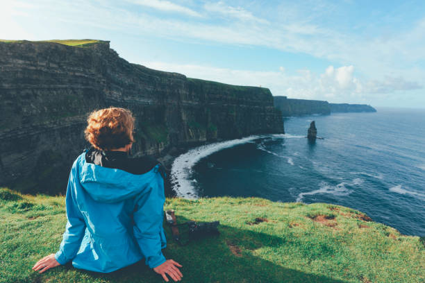 la femme regarde des falaises de moher en irlande - republic of ireland cliffs of moher landscape cliff photos et images de collection