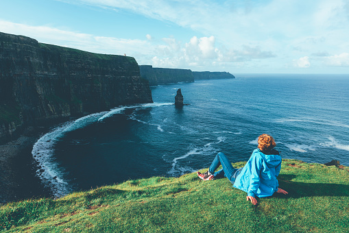 Woman looks at Cliffs of Moher in Ireland