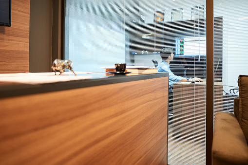 Shot of a modern office interior with a businessman working in his cubicle
