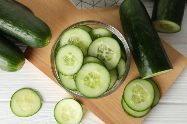 istock Board with cucumbers and towel on wooden background, top view 1206242096