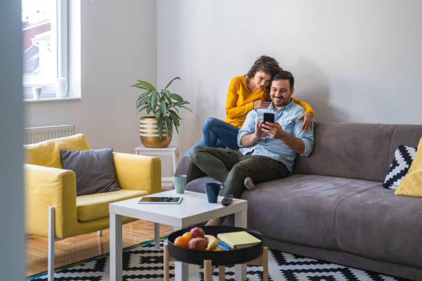 istock Couple using mobile phone at home stock photo 1206242817