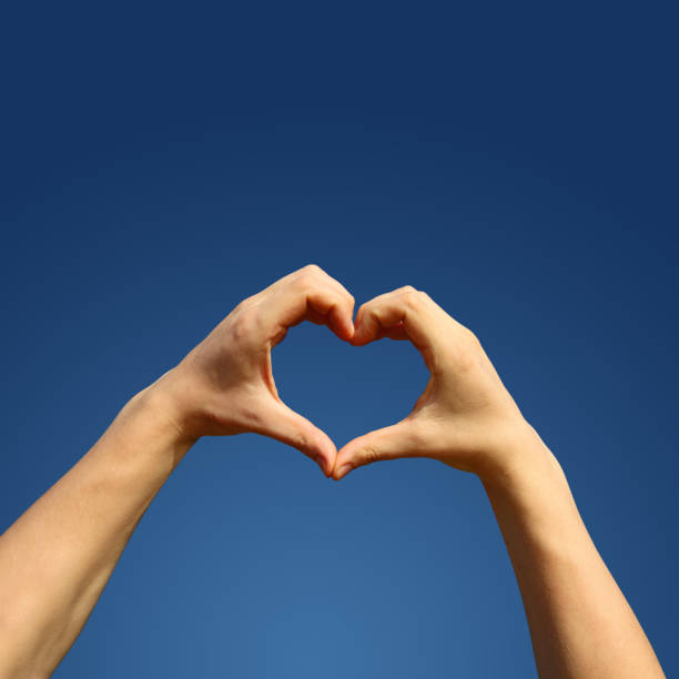 istock Hand shaped heart against sunset 1206243698