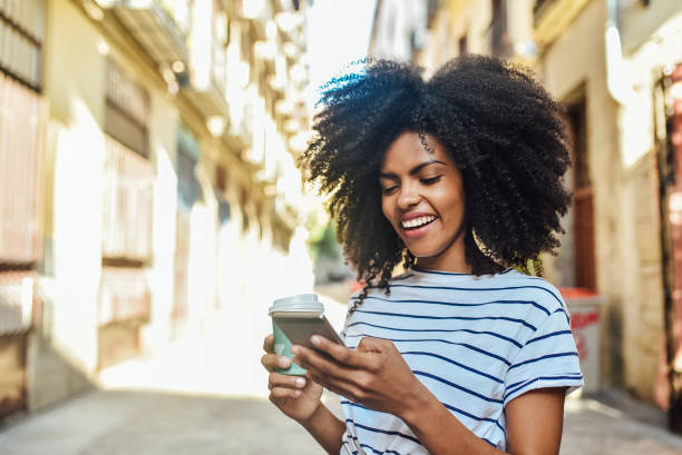 istock Beautiful girl drinking coffee and using smartphone on her way 1206243820