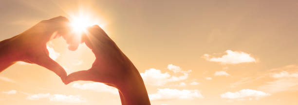 istock Hand shaped heart against sunset 1206244060