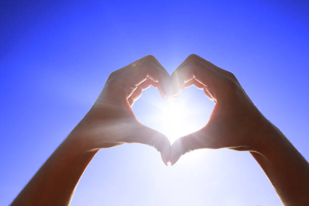 istock Hand shaped heart against sunset 1206244213