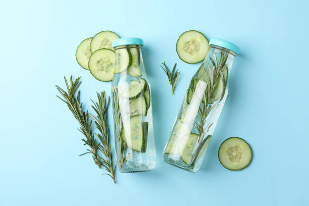 istock Bottles with infused cucumber water on blue background, top view 1206244380