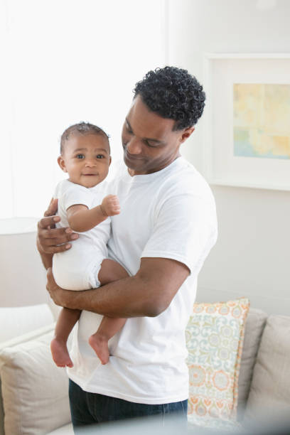 istock Father holding daughter in living room 1206244471