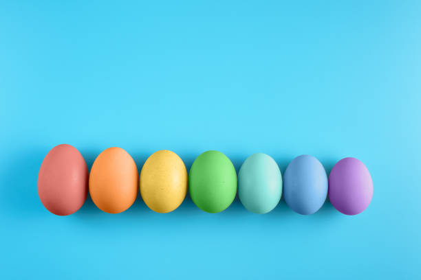 istock Top view of seven bright painted easter eggs on blue surface. Colorful easter eggs decoration. Flat lay, top view. with copy space for text. 1206246557
